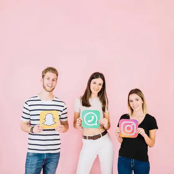 Three smiling people holding Snapchat, WhatsApp and Instagram app icons against a pink background